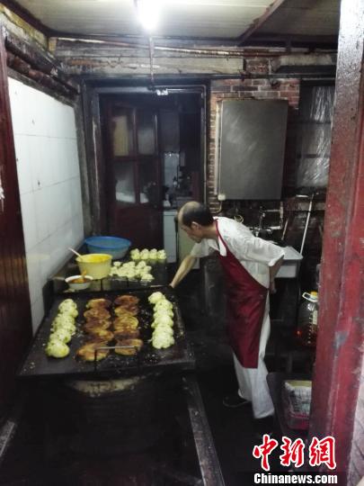 图为阿大在制作“阿大葱油饼”。(资料图) 潘索菲 摄